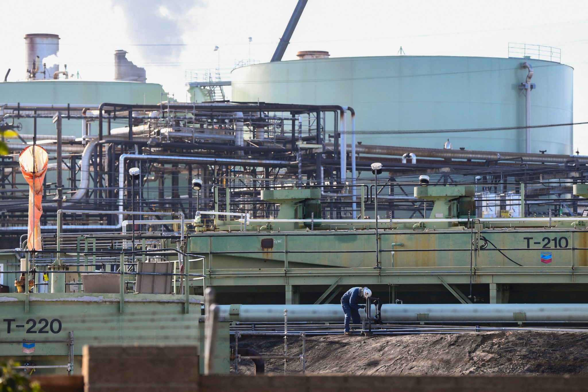 1 月 26 日，一名工人在加利福尼亚州埃尔塞贡多的雪佛龙炼油厂拍照